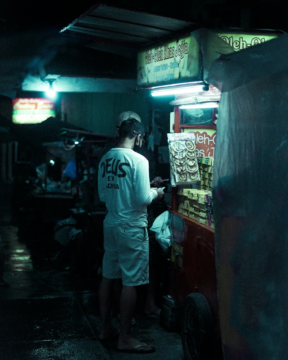 man in white shirt standing near store