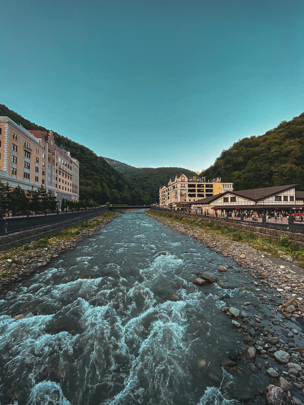 brown concrete building near river under blue sky during daytime