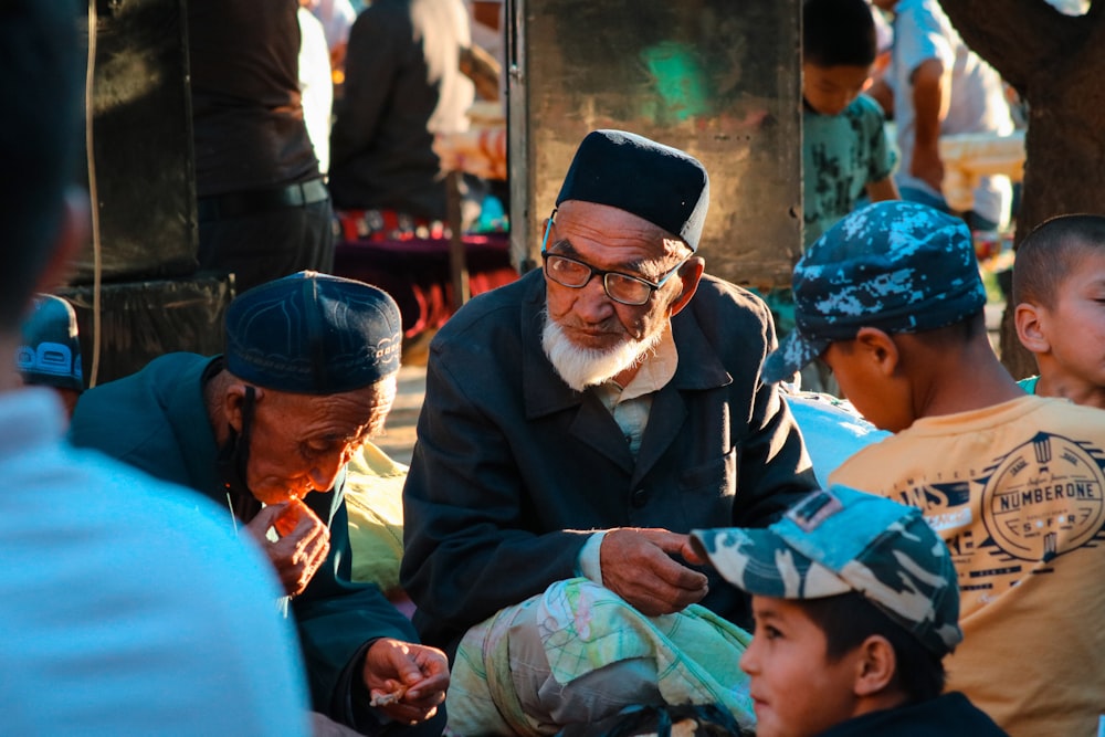 man in black suit jacket sitting beside woman in green hijab