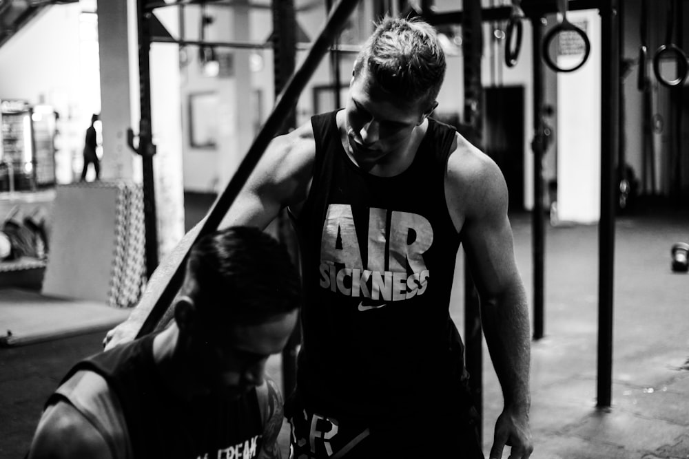 a man standing next to another man in a gym