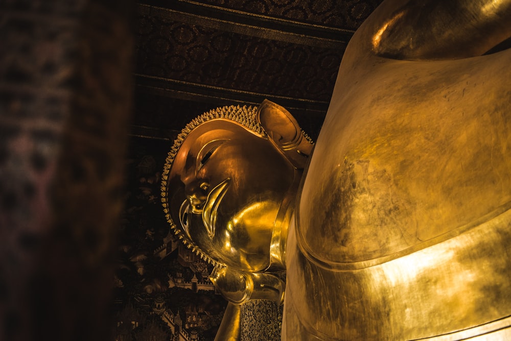 a large golden buddha statue sitting in a room