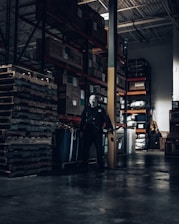 man in black leather jacket standing near black wooden shelf