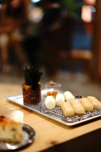 Elegant shot of assorted savory snacks neatly displayed on a wooden tray with natural lighting.