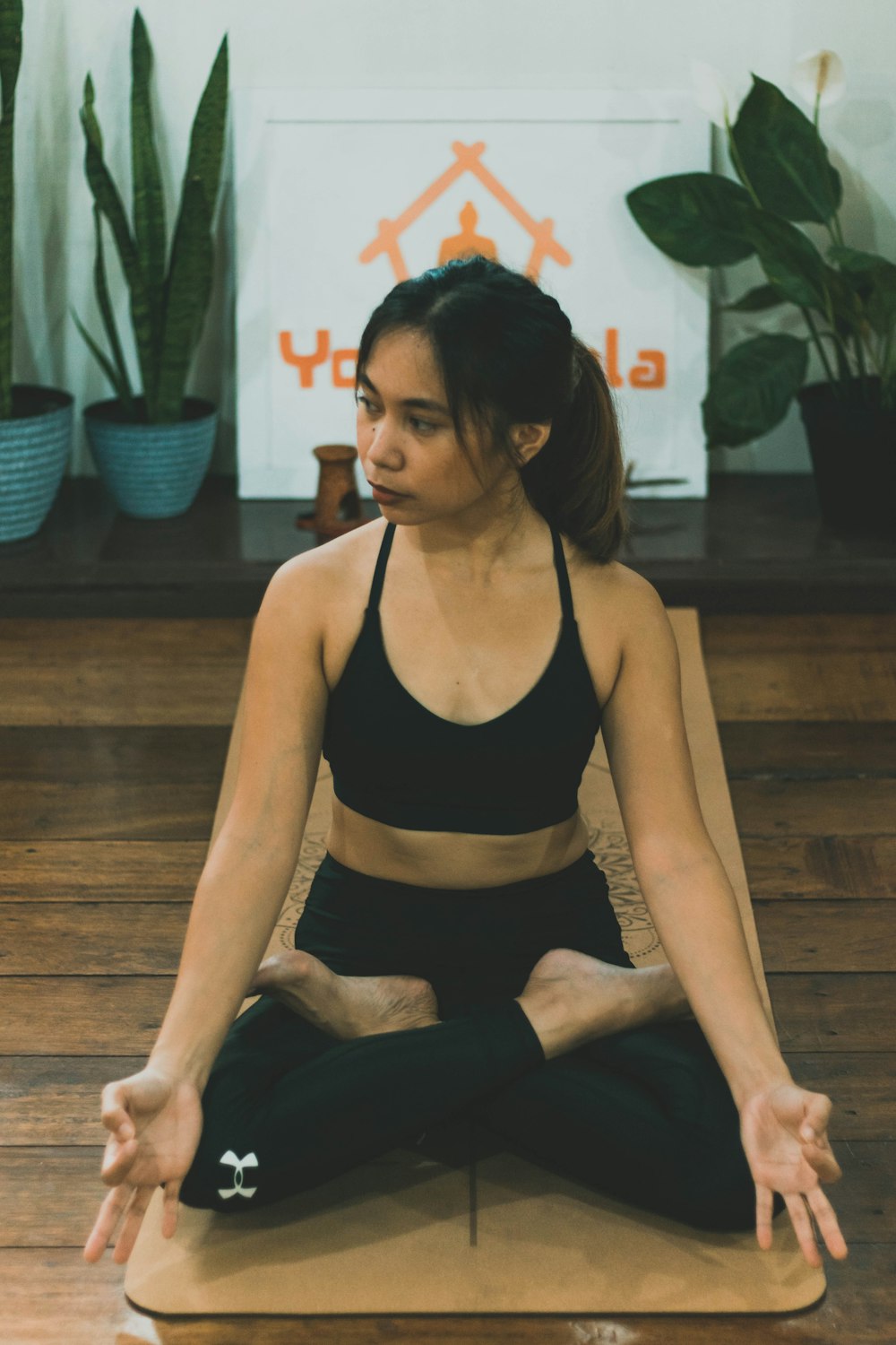 woman in black tank top and black leggings sitting on brown wooden bench