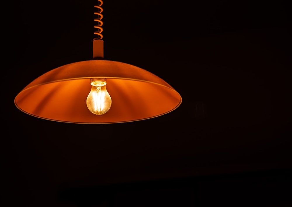brown pendant lamp turned on in dark room