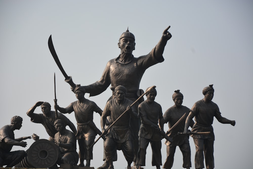 a statue of a man holding a sword and surrounded by other statues