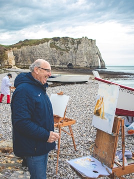 man in black jacket sitting on brown wooden chair