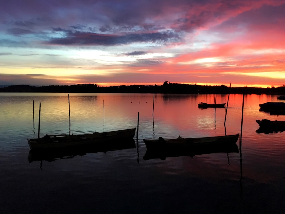silhouette de bateau sur l’eau au coucher du soleil