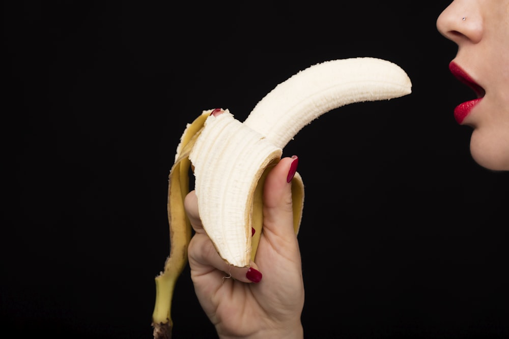 Person, die gelbe Bananenfrüchte hält