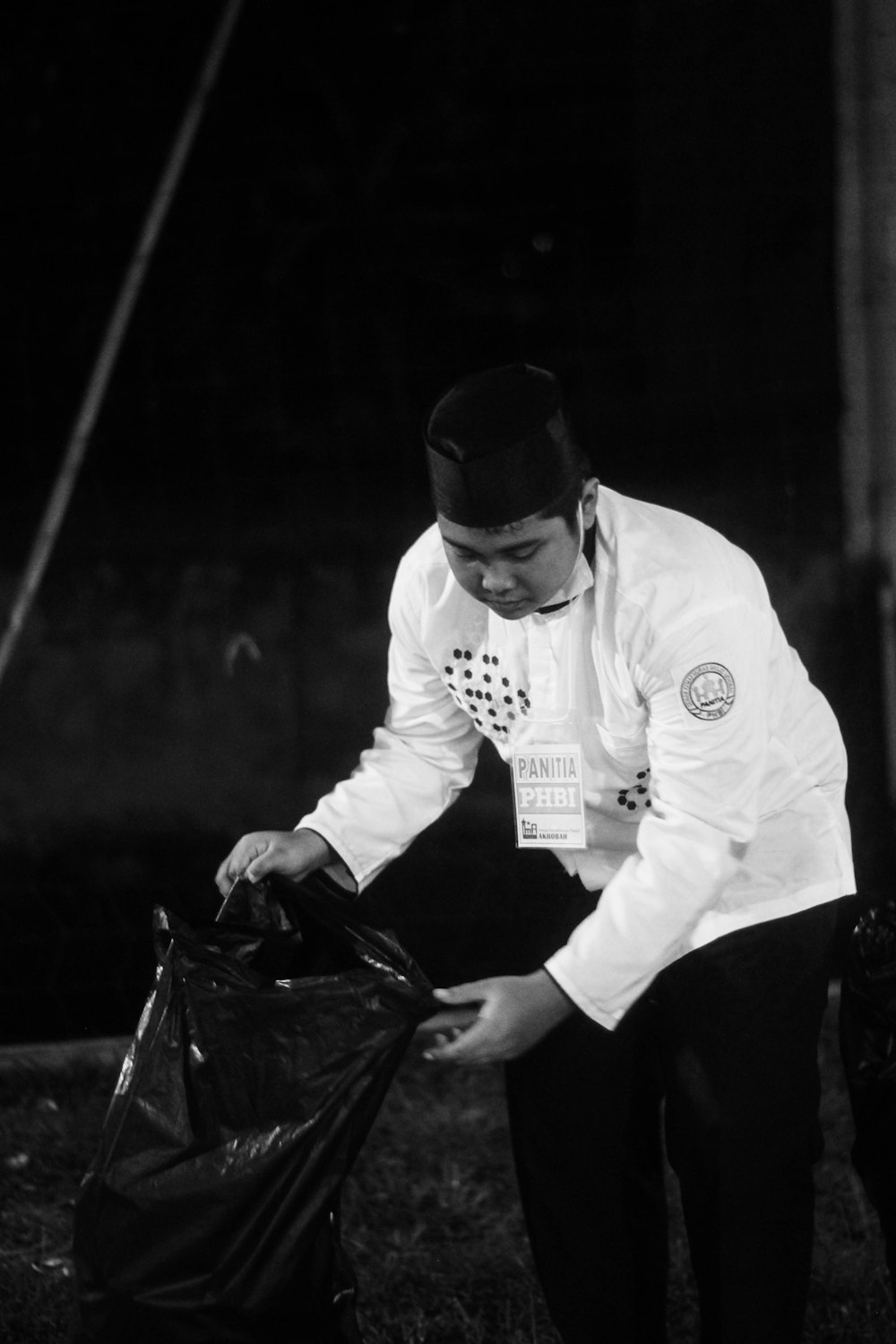 man in white long sleeve shirt holding black plastic bag