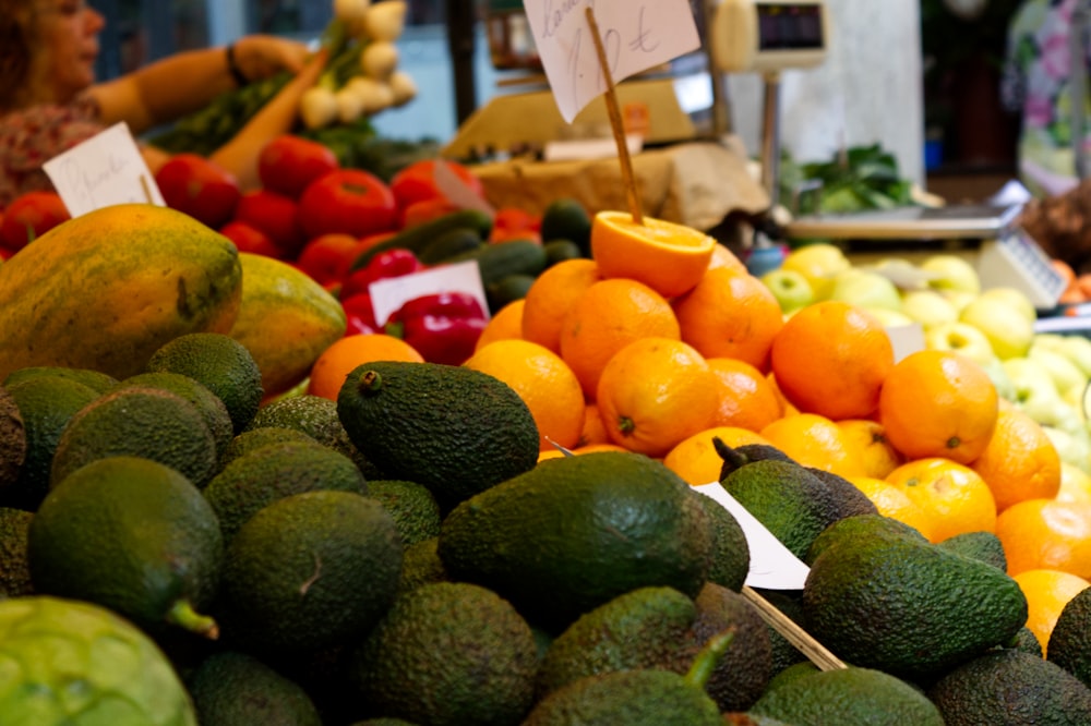 green and orange fruits on display