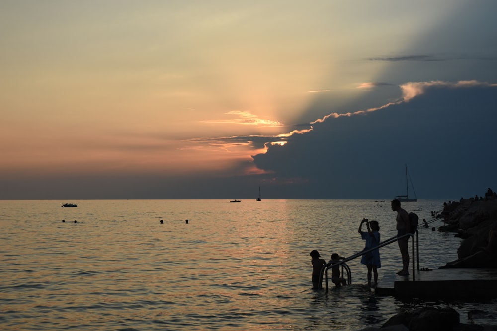 Silhouette von Menschen auf dem Boot während des Sonnenuntergangs