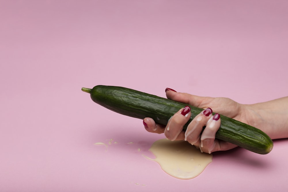 green cucumber on pink surface