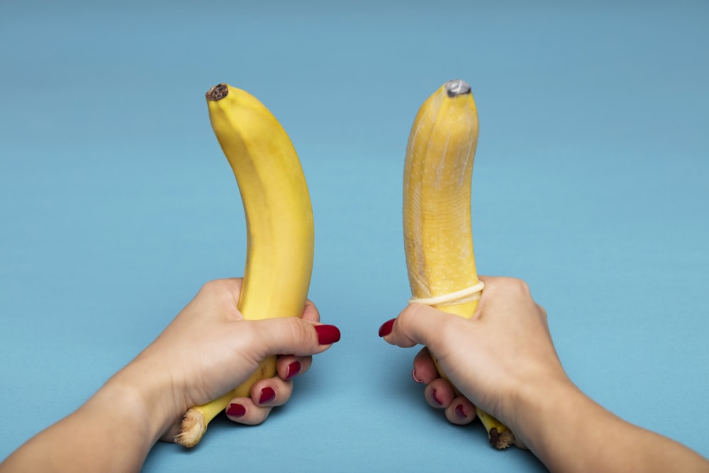 personne tenant un fruit de banane jaune