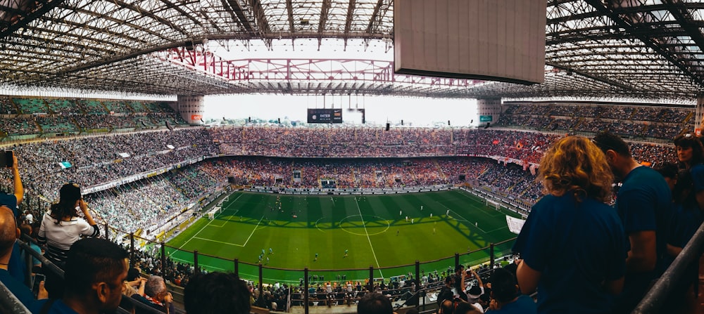 people watching soccer game during daytime