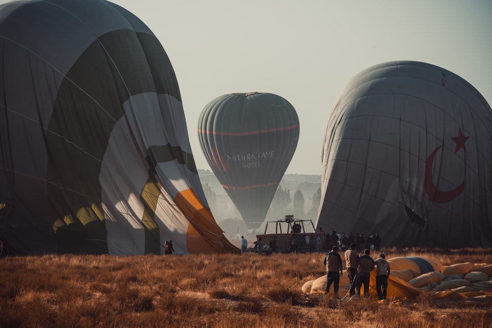 people standing near hot air balloons during daytime