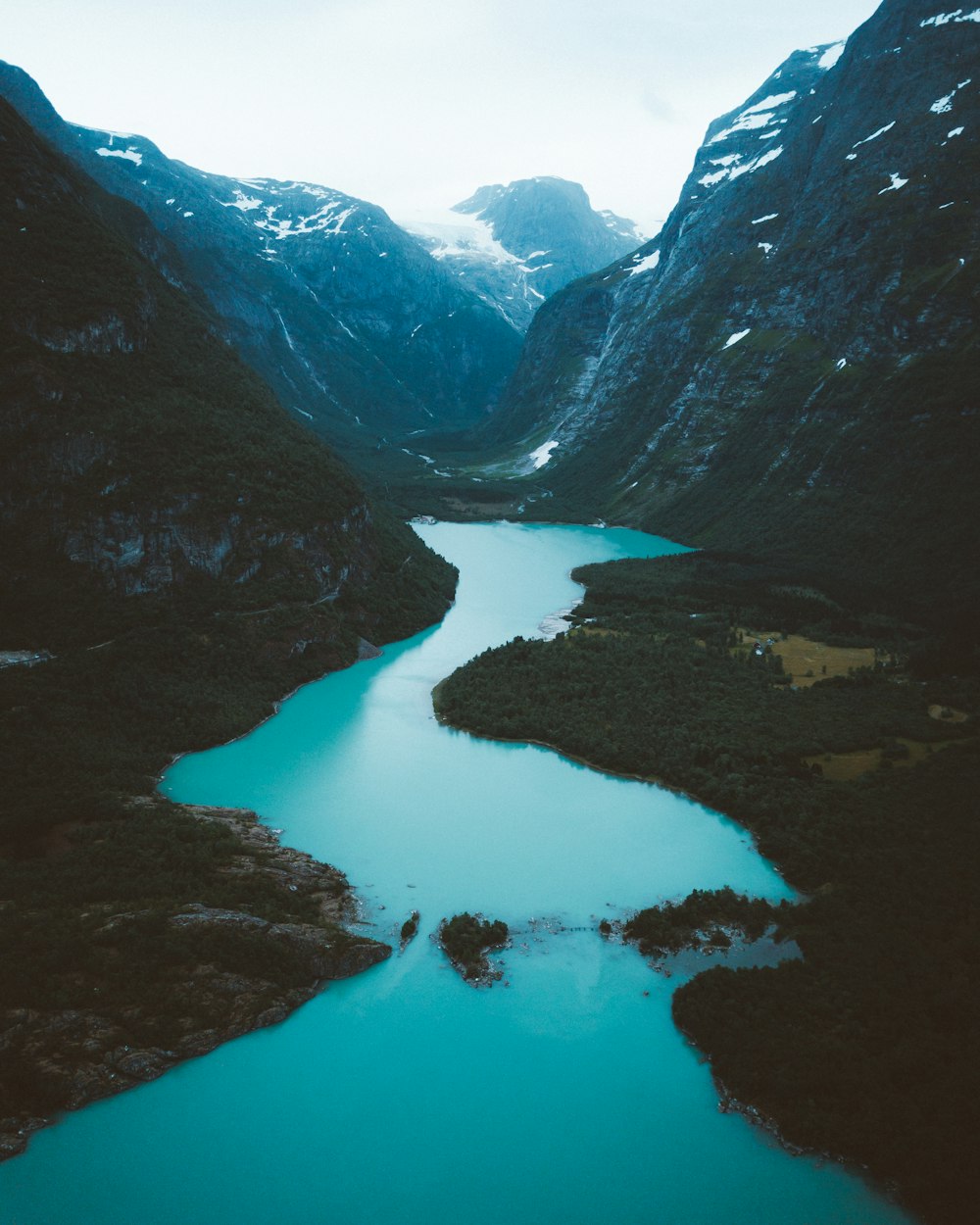 lake in between mountains during daytime