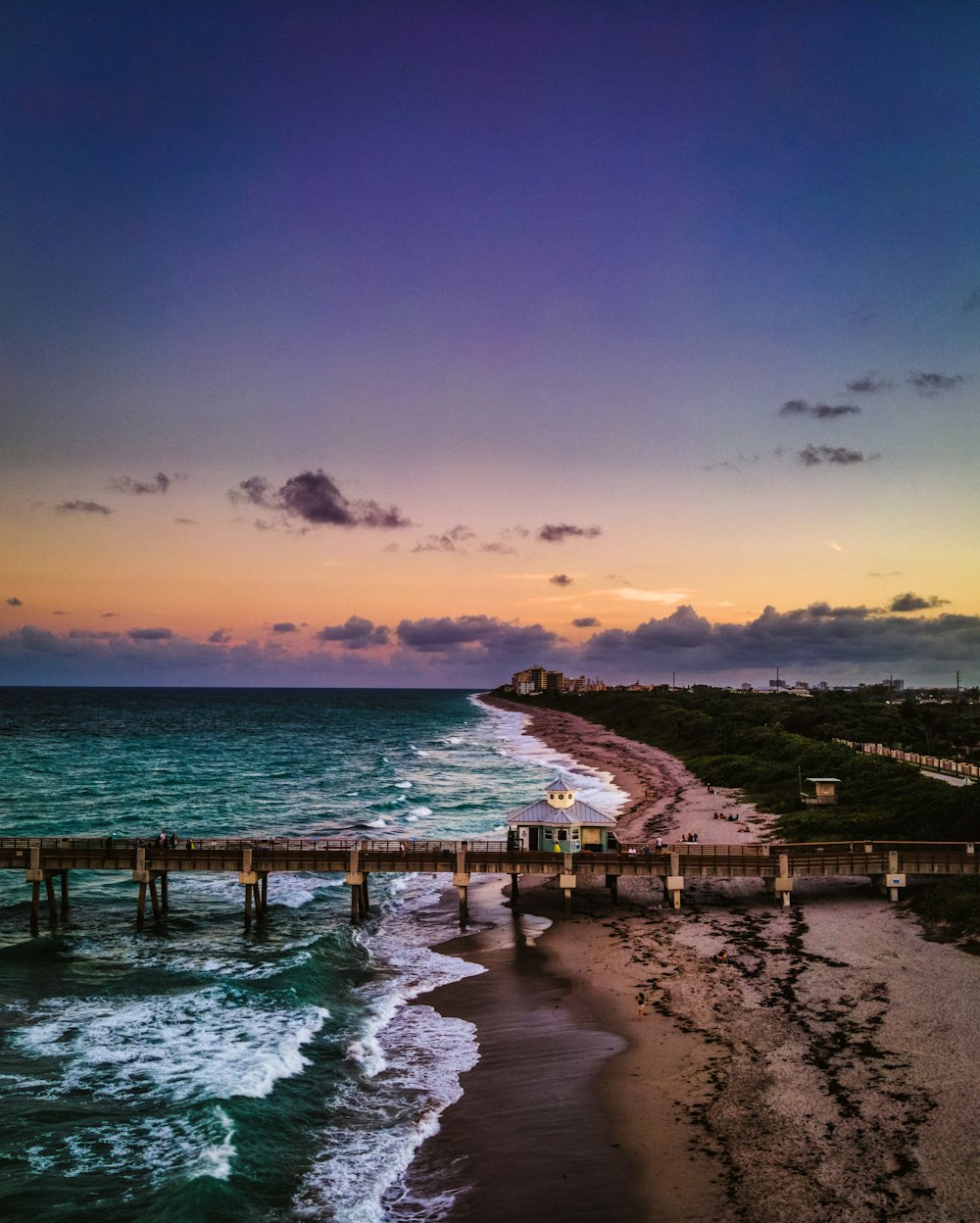 muelle de madera marrón en el mar durante la puesta del sol