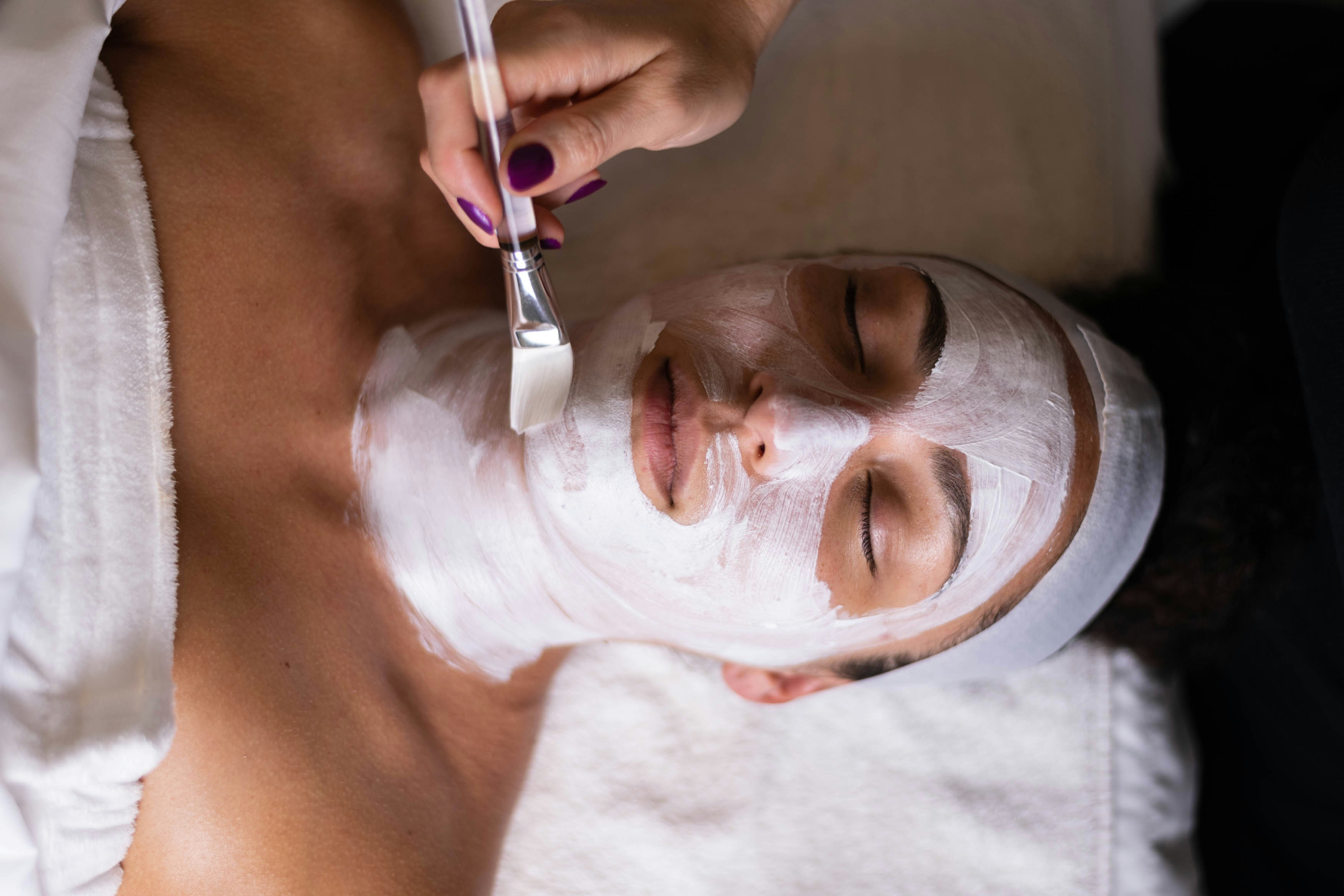 a woman getting facial treatment by Heidi's Beauty Effect - a beauty salon in Springwood, QLD