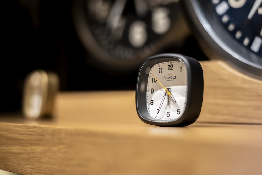 black and white analog alarm clock at 10 00