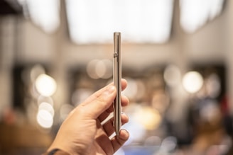 person holding silver tube type vape