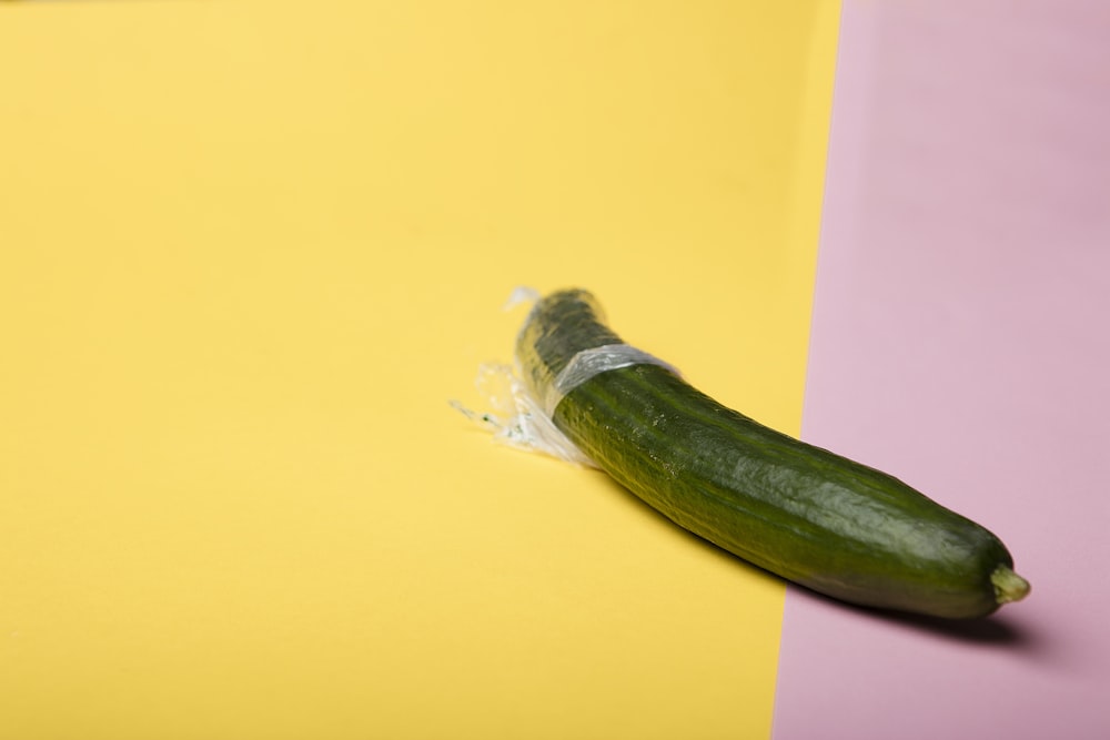 green cucumber on yellow surface
