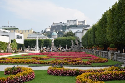 The serene gardens of Salzburg’s Mirabell Palace with blooming flowers and statues.