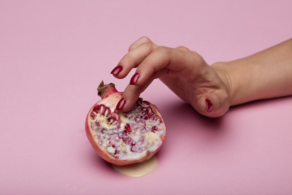 person holding a pink doughnut