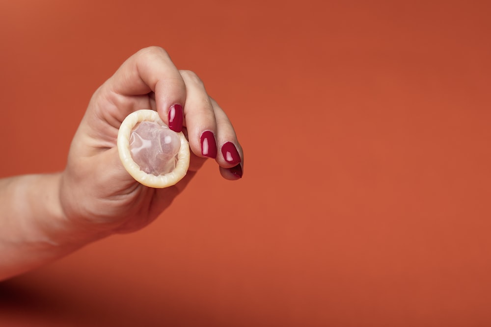 persona sosteniendo un vaso transparente con líquido amarillo