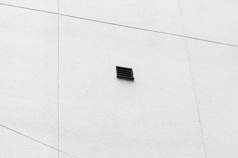 Fenêtre noire sur mur de béton blanc