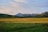 An aerial view of a picturesque field with mountains in the background.