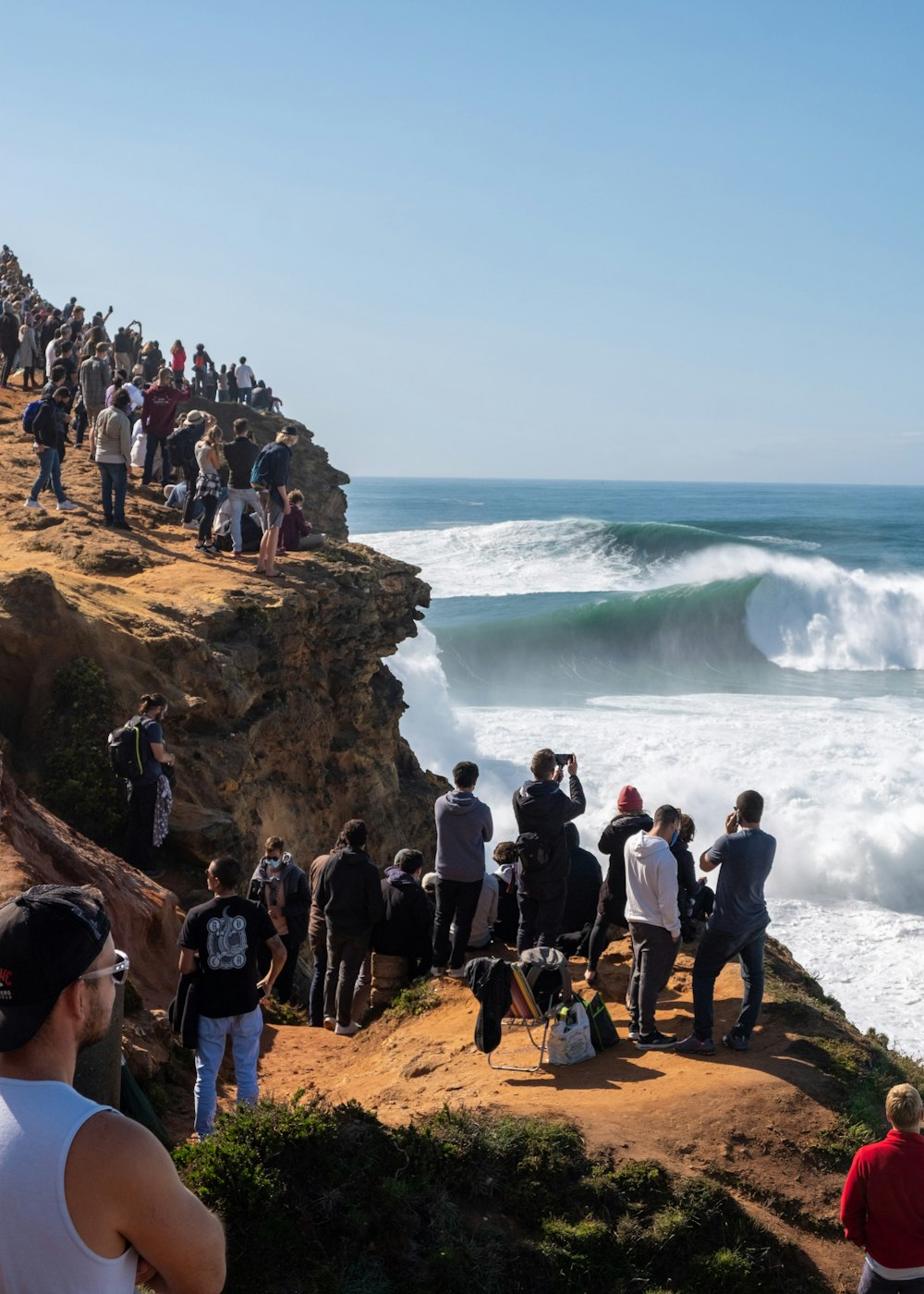 people standing on brown rock formation near body of water during daytime