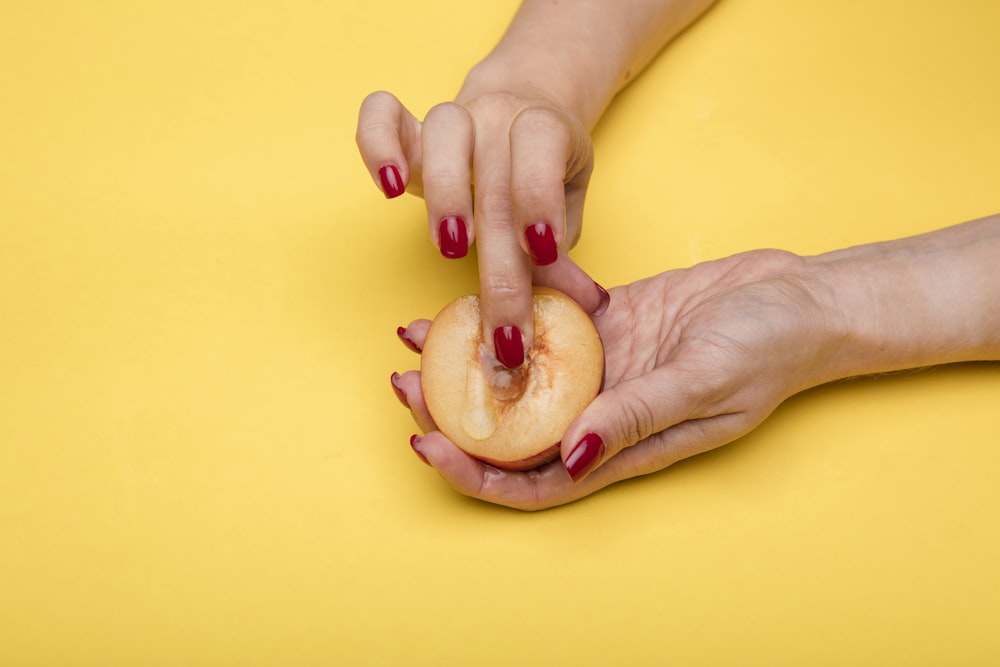 Persona que sostiene fruta de manzana en rodajas