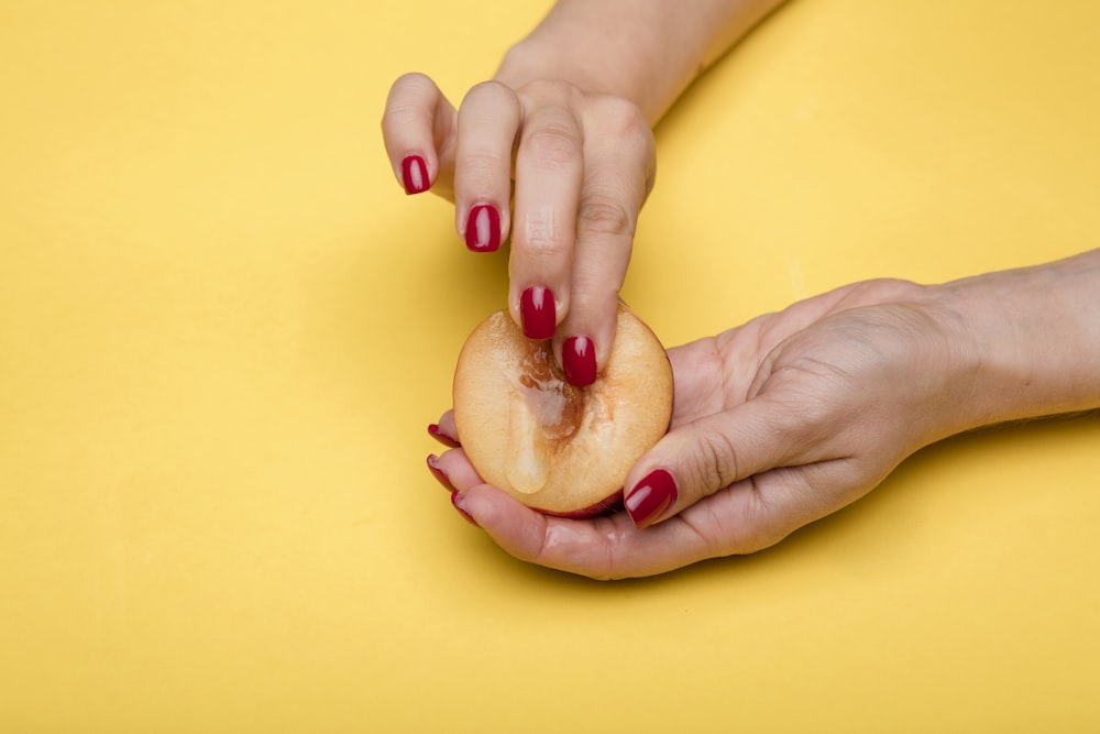 person holding red and white heart shaped food