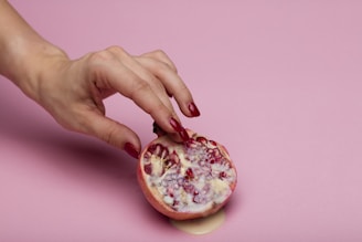 person holding a round pink and white cake