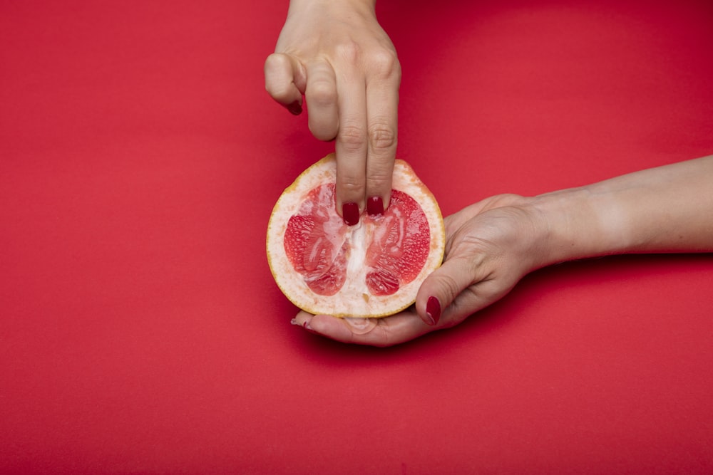 person holding sliced of watermelon