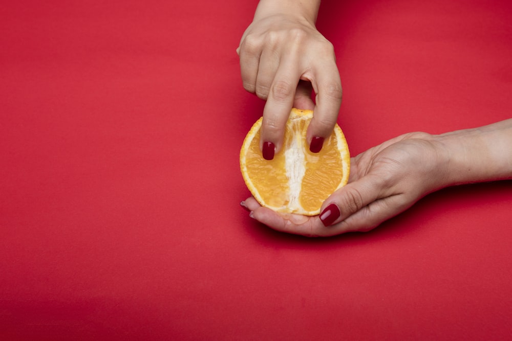 person holding brown bread on red textile