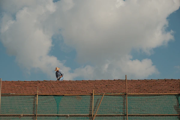 A skilled worker installing elegant terrace flooring under a clear blue sky.