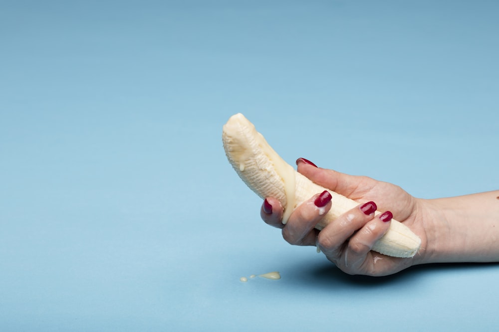 Persona sosteniendo conchas marinas blancas durante el día