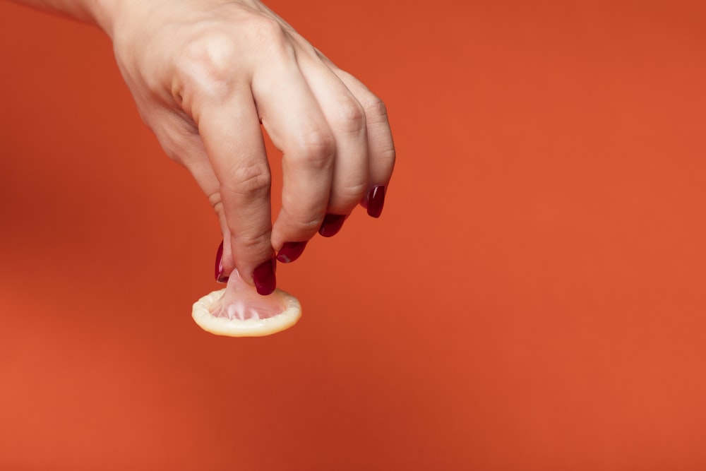 person holding white ceramic heart shaped ornament