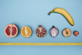 Close-up of healthy fresh fruits and measuring tape on table.