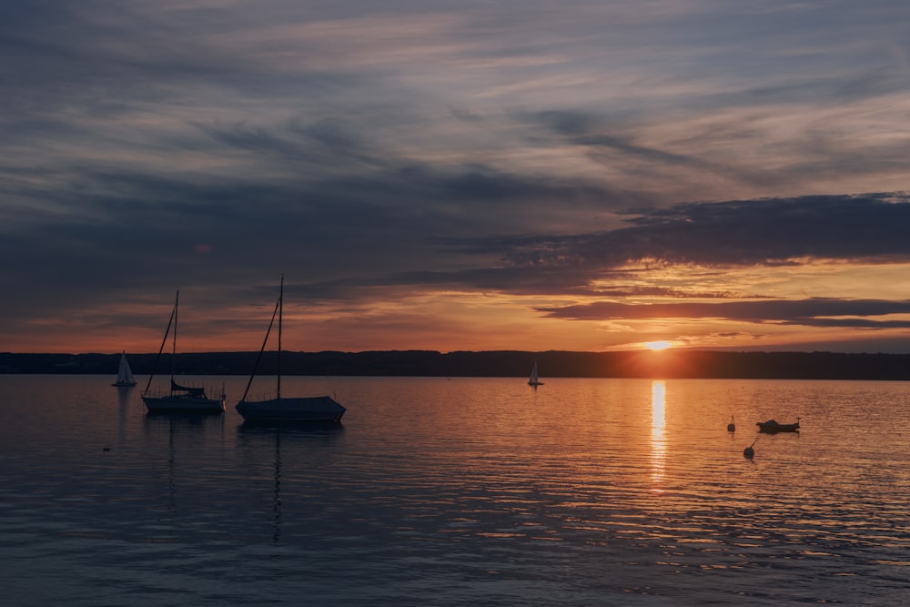 silhouette of boat on sea during sunset