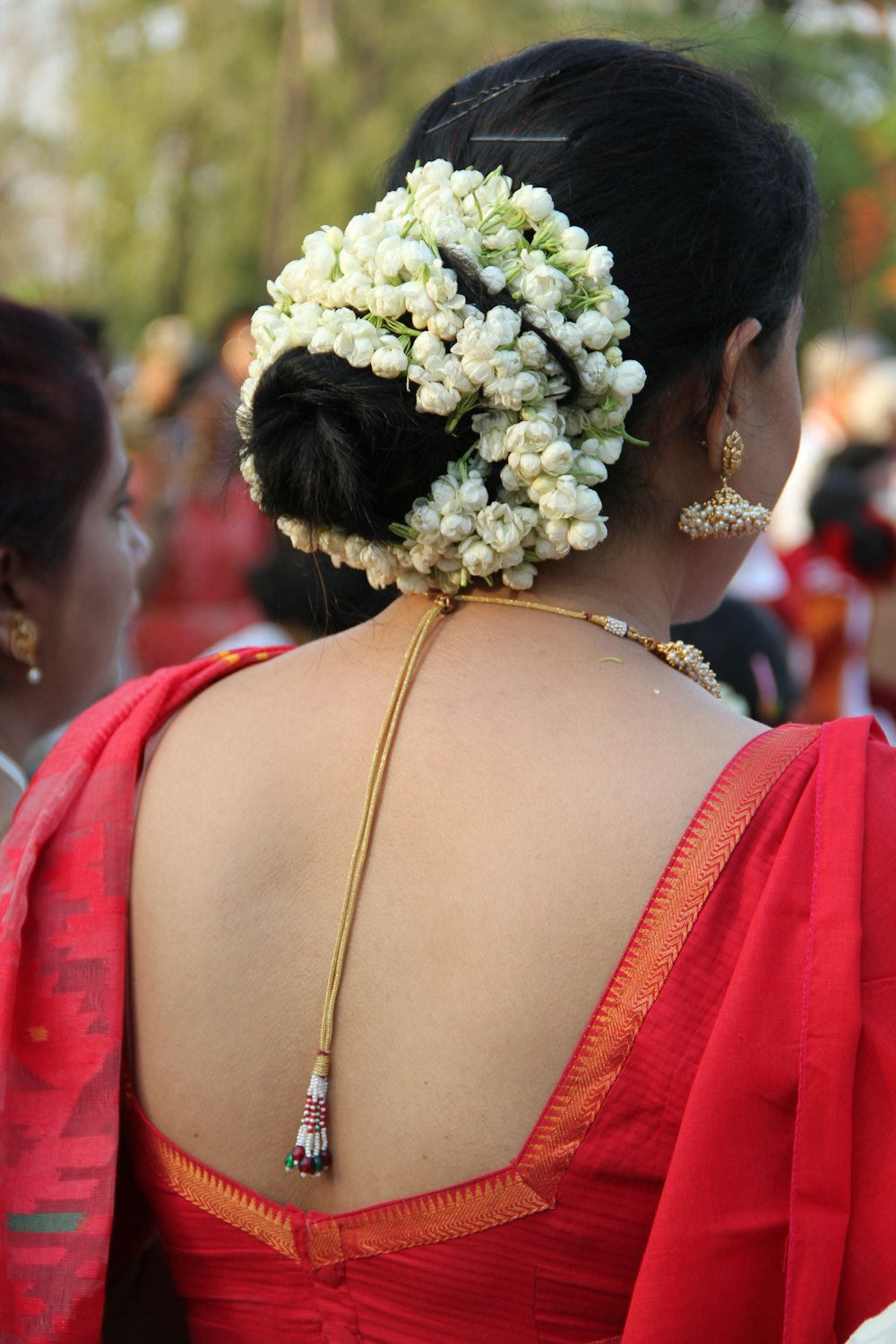 woman in red and white floral dress with white flower on head