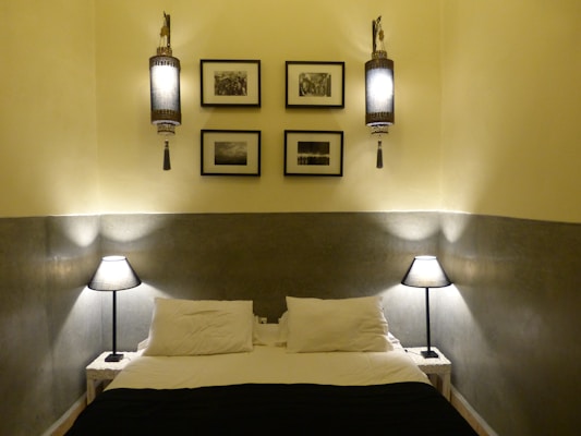 An elegant bedroom setup with a wooden bed frame, soft bedding, and bedside lamps.