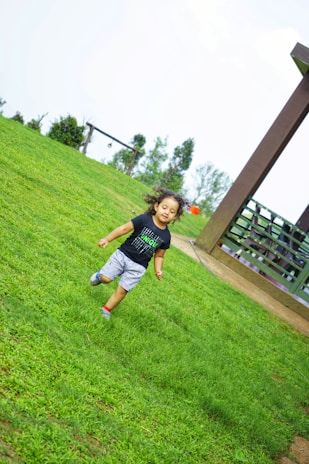 A happy child playing barefoot on a treated lawn, highlighting the family-safe aspect of the service.