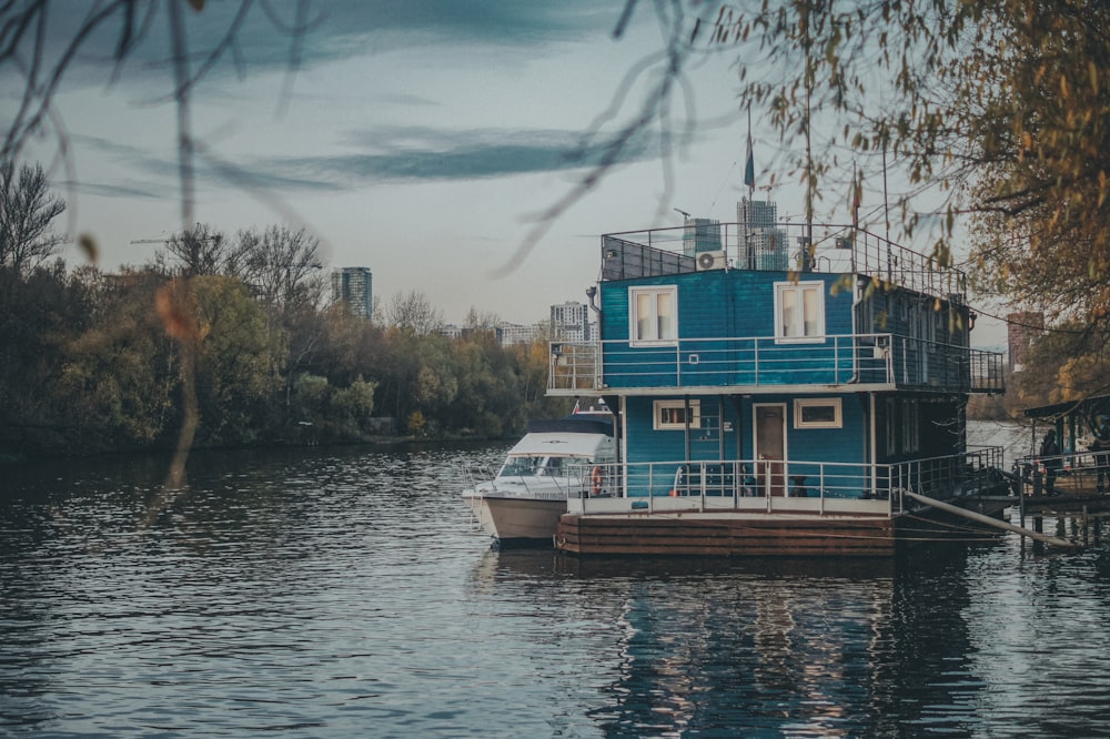 blue and white boat on water near green trees during daytime