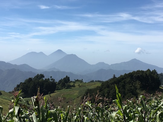 green grass field near mountains during daytime in Quezaltenango Guatemala