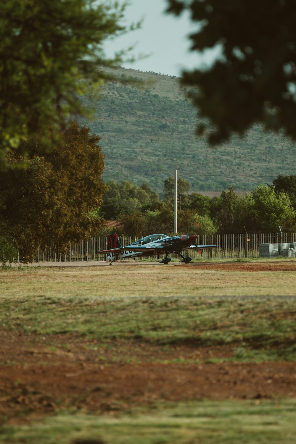 blue and white airplane on brown field during daytime