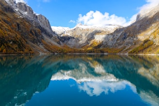 blue lake near brown and white mountains under blue sky during daytime