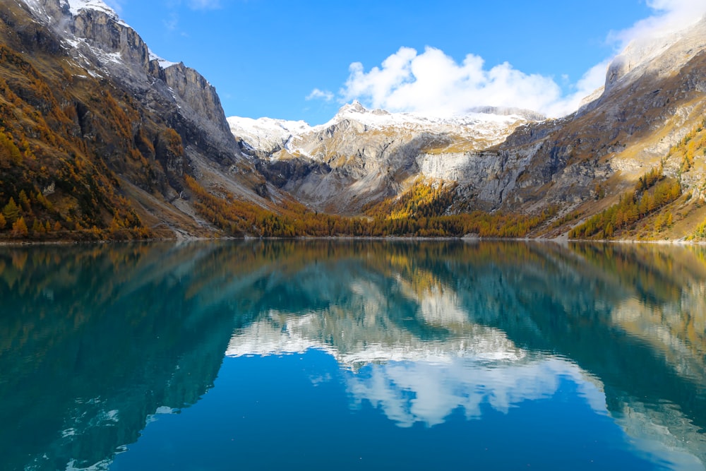 Lago blu vicino a montagne marroni e bianche sotto il cielo blu durante il giorno